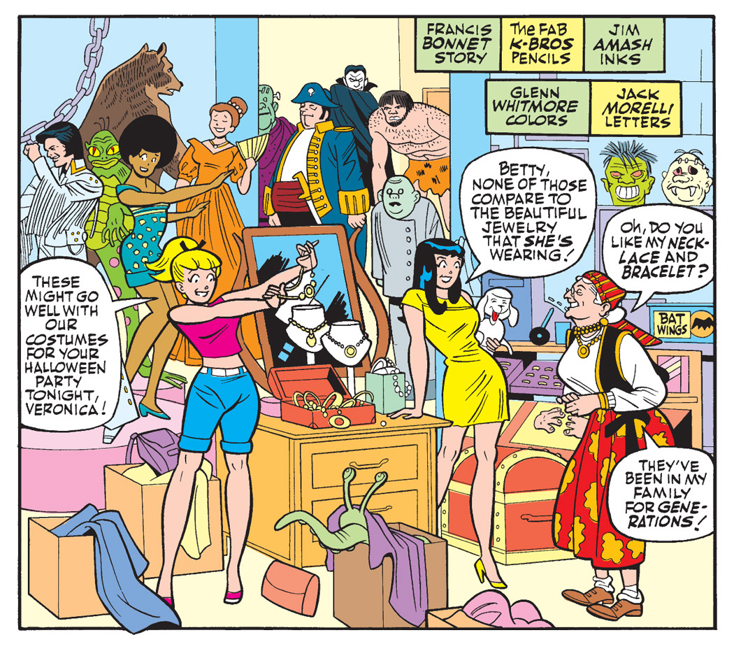Panels from an Archie Comics story. Betty and Veronica are shopping at a crowded vintage store for their Halloween party. Betty says some jewelry might go well with their costumes. Veronica says they're nothing compared to the jewelry the shop owner is wearing, an older woman with gray hair wearing a scarf tied around her head. The woman says her jewelry has been in her family for generations. The shop is cluttered with life-sized monster manequins, costumes, masks, and props.