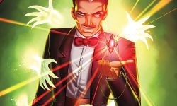 Kardak, an older slender white main with dark hair and a gray streak, is dressed in a tuxedo and looking out at the viewer with a sinister smirk on his face. A magical ruby on a gold chain levitates above his outstretched palm, and he stands on a stage in front of a green mist with ghostly hands reaching out.